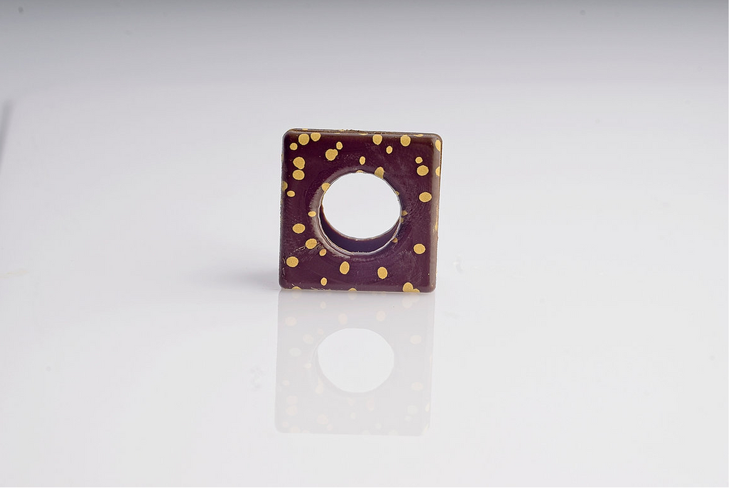 DEC21/04. Dark chocolate square with gold dots. Case Size: 144